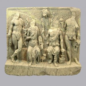 Das Bild zeigt ein römisches Relief aus Sandstein. Auf dem Relief sind 5 Götter zu sehen: In der Mitte sind sitzend die Hauptgottheiten Vulcanus und Minerva zu sehen. Hinter und neben ihnen stehen Apollo, Fortuna und Mercur. Die Steinmetz-Arbeit ist sehr sorgfältig ausgeführt. Nur die Köpfe der Figuren fehlen. Sie wurden in der Antike abgeschlagen. Das Relief zeigt keine Farbspuren mehr, war in der Antike aber bunt bemalt.