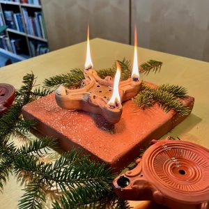 Eine römische Öllampe erhellt das Umfeld in sanftem Licht